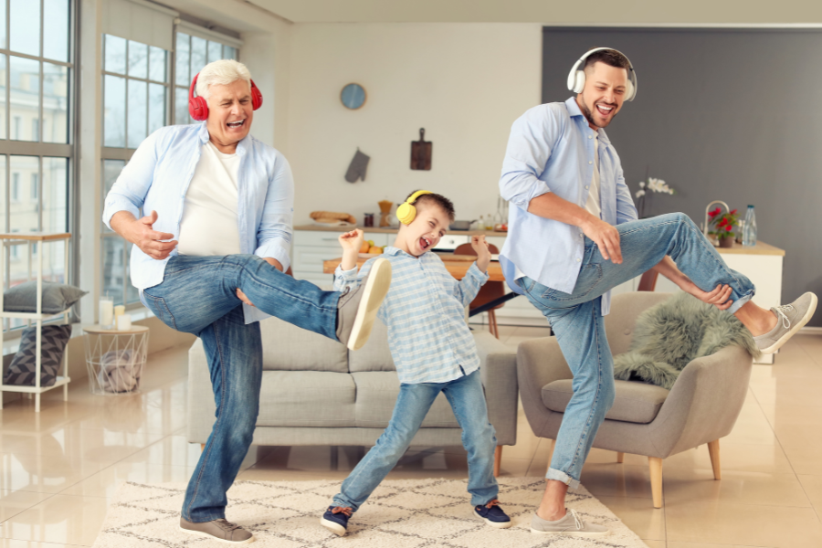 Une session musicale joyeuse pour célébrer la Fête des Pères en famille. Trois générations – grand-père, père et fils – dansant ensemble avec des casques