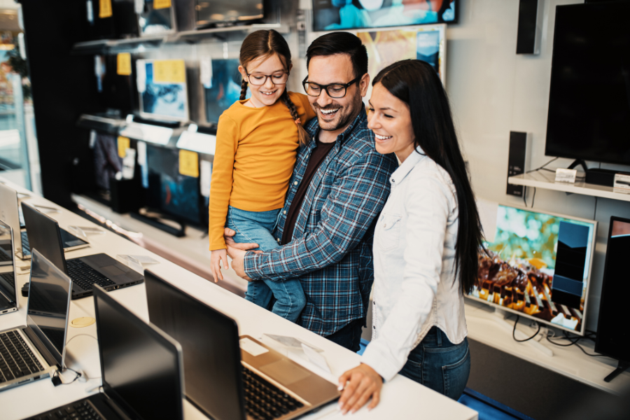 Acheter un ordinateur portable en magasin Gitem avec des conseils personnalisés Famille en train de comparer des ordinateurs portables dans un magasin Gitem