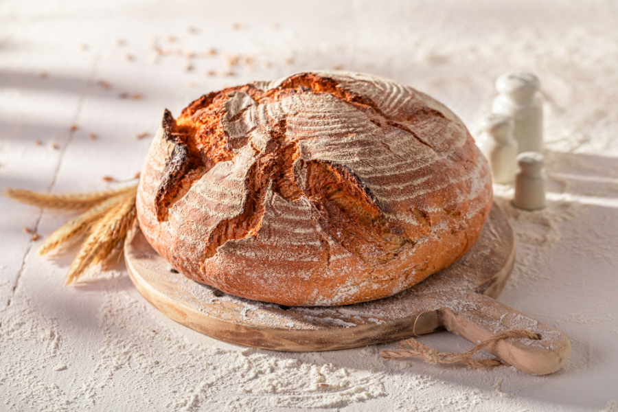 Machine à pain – Préparer facilement du pain maison avec Gitem Machine à pain en fonctionnement avec un pain maison fraîchement cuit et tranché sur une planche.