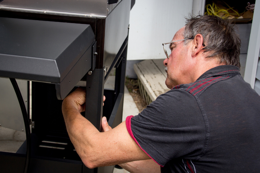 Réparation d’un barbecue électrique qui disjoncte – conseils Gitem Homme réparant un barbecue électrique
