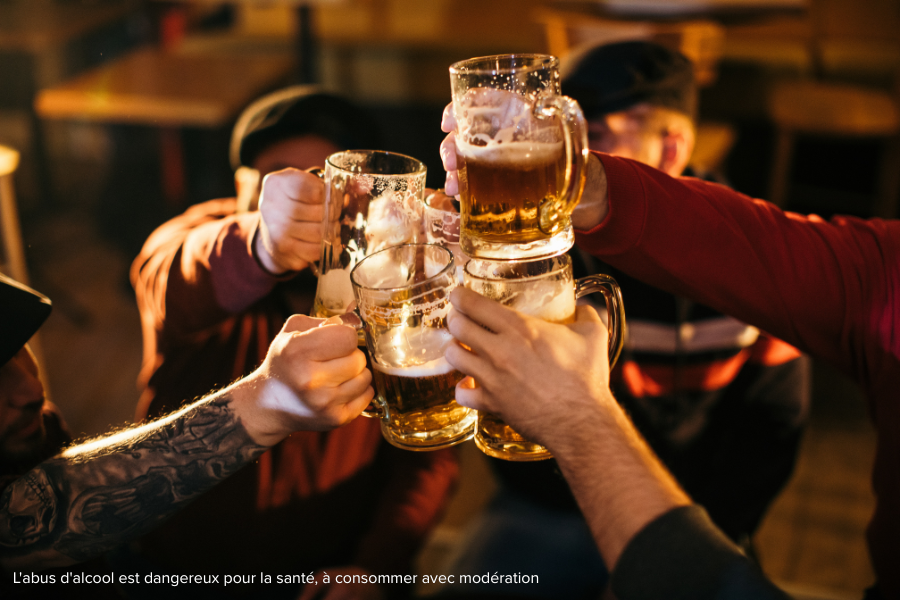 Partager un moment convivial entre amis autour d’une bière pression Groupe d’amis trinquant avec des chopes de bière lors d’un moment convivial autour d’une bière pression